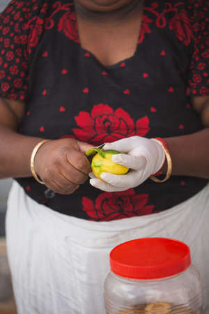 A woman peels mango at a wedding receptionの写真素材
