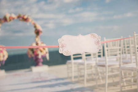 A sign on the backdrop of wedding arch and the seaの写真素材