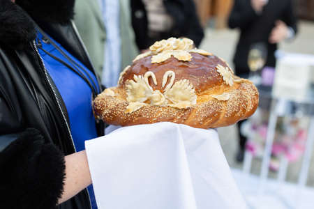 Wedding round loaf at the wedding in the hands of parentsの写真素材