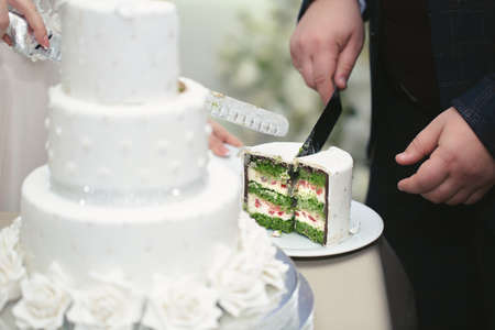 The bride and groom cut a gorgeous wedding cake at a banquetの写真素材