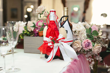 Decorated bottles of champagne on the newlyweds table.の写真素材