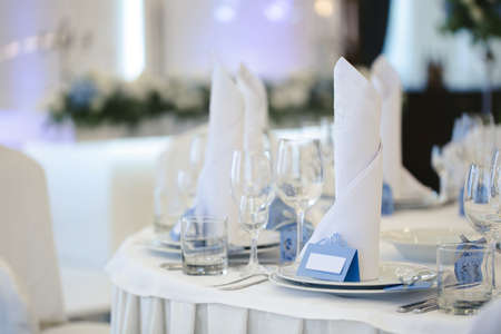 Beautiful setting of the wedding banquet table in the restaurant with the name of the guest