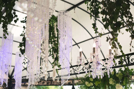 Beautiful luxurious romantic decor for a wedding celebration. The arch is decorated with draped fabric and a crystal chandelierの写真素材