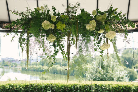 Details. Wedding ceremony in the open air of fresh flowers, with candles. Gentle and beautiful wedding decor for newlywedsの写真素材