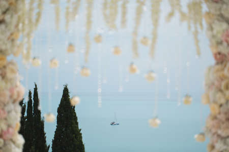 Wedding arch with flowers and beads on a background of the ocean closeupの写真素材