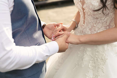 Bride and groom hold hands during the wedding ceremony.