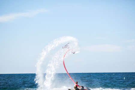 A rider on a flyboard in the ocean does difficult stunts.の写真素材