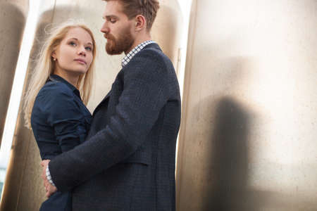 Man and woman pose in front of the large metal pipes.の写真素材