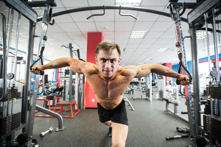 Young Bodybuilder Is Working On His Chest With Cable Crossover In Gym.