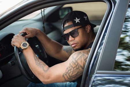 Young african male driver driving a car.