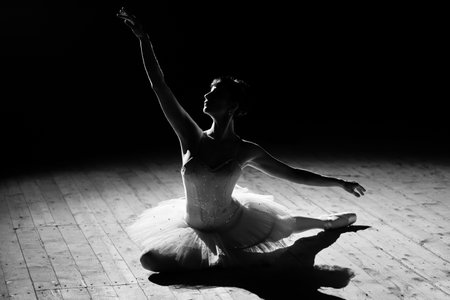 A young beautiful ballerina poses on the stage of the theater.の写真素材