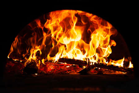 Hot flame of fire in oven. Warm evening by the fireplace.の写真素材