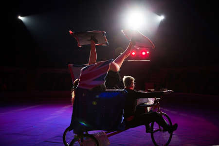 A juggler on a bicycle under the dome of the circus.の写真素材