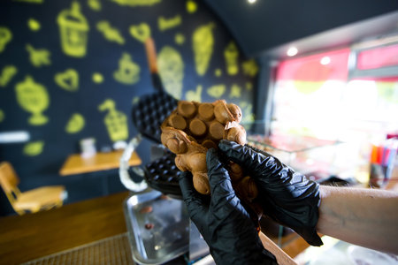 Waffle iron in the kitchen at shop. Preparing Hong Kong waffle.の写真素材