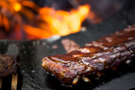 Grilled pork baby ribs with barbecue sauce on the grill. Festival street food.の写真素材