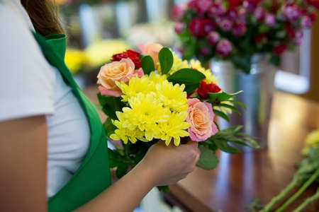 Workshop florist, making bouquets and flower arrangements. Woman collecting a bouquet of flowers.