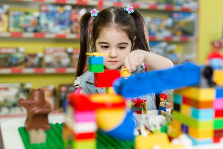 Little girl playing with building blocks in the store.の写真素材
