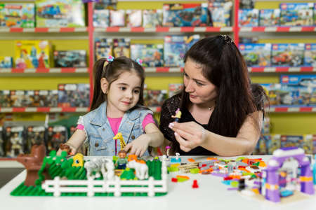 Mother with a little daughter playing with blocks.