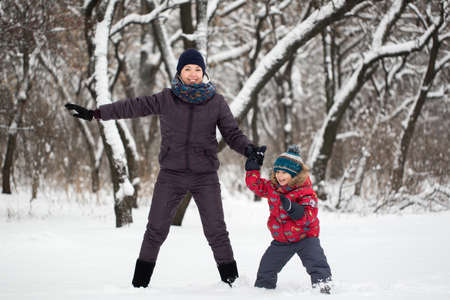 Happy mother and baby in winter park.