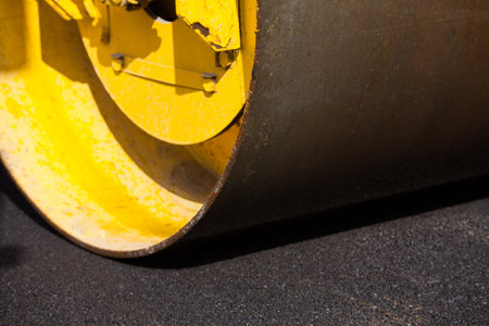 Pavement machine laying fresh asphalt or bitumen on top of the gravel base during highway construction.の写真素材