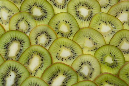 Bright green background with slices of juicy kiwi. Healthy food background