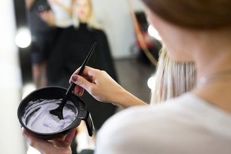 paint with a brush in the hands of a hairdresser.の写真素材