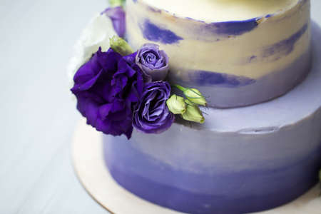 Wedding two-tiered purple cake with fresh flowersの写真素材