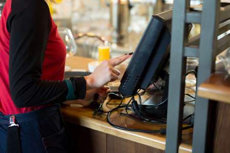 A waiter of a modern cafe or bar enters an order or payment via a tablet or a seekipperの写真素材