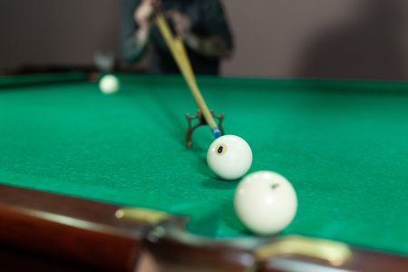 Mans hand and Cue arm playing snooker game or preparing aiming to shoot pool balls on a green billiard table.の写真素材
