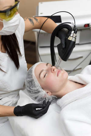 Hair removal cosmetology procedure from a therapist at cosmetic beauty spa clinic. Laser epilation and cosmetology.の写真素材