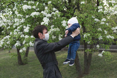 Child and man in medical protective mask on the street. Epidemic of virus covid.の写真素材