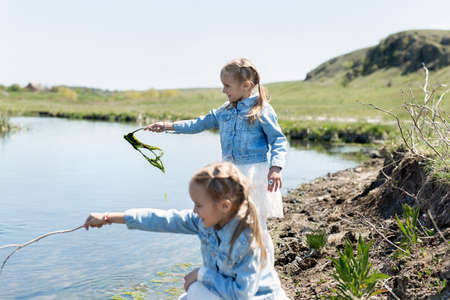 Two twin sisters have fun and play near the reservoirの写真素材