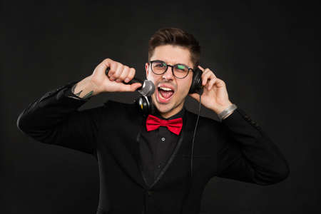 DJ with headphones and microphone on a black background.の写真素材