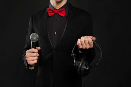 DJ with headphones and microphone on a black background.の写真素材