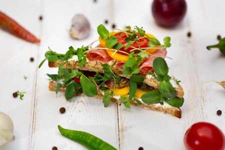 Sandwiches with sausage, cheese and micro-greens on a white background.の写真素材