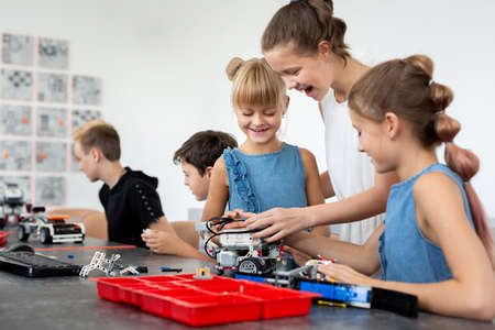 Education, children, technology, science and people concept - group of happy kids with laptop...