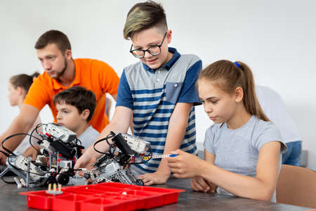 Kids working with teacher on their robot education project.