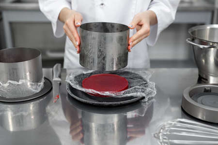 The pastry chef collects the cake. Berry jelly filling for cake.