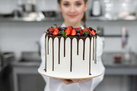 Close-up of a cake in the hands of a pastry chef