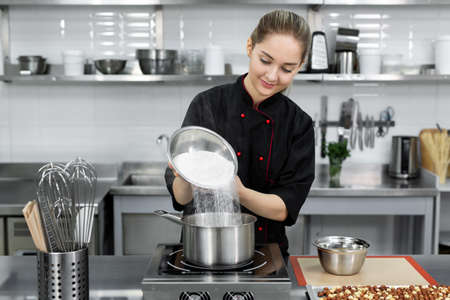 Pastry chef pours the sugar into a saucepan