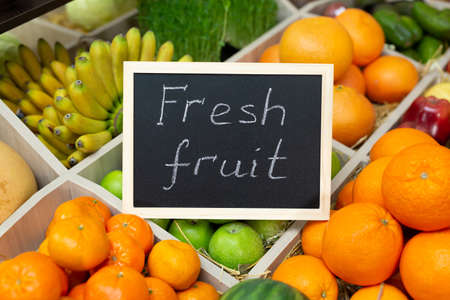 Inscription in chalk fresh fruit on the sign in the vegetable storeの写真素材