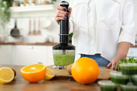 Close-up of the blender process. Im making a green smoothie with whitgrass. Mixing in a blender bowl