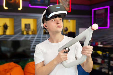 Teen, boy playing on a video game console, emotional gamer shooting a game using a gun controller in...