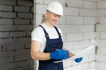 Portrait of a laughing architect-builder studying the floor plan.の写真素材