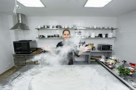 The pastry chef claps his hands and the flour is scattered all over the kitchen