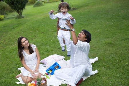 Family picnic of a happy family in the park on a green lawnの写真素材