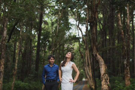 Walking the young bride and groom in the woods.の写真素材