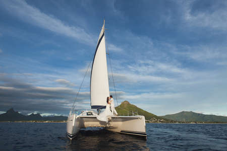 Beautiful wedding couple bride and groom on yacht at wedding day outdoors in the sea. Happy marriage...