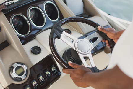 Yachts captain holds the wheel with his hands.の写真素材