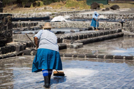 People collect the salt on a Sunny day on the shores of the Indian ocean in Mauritiusの写真素材